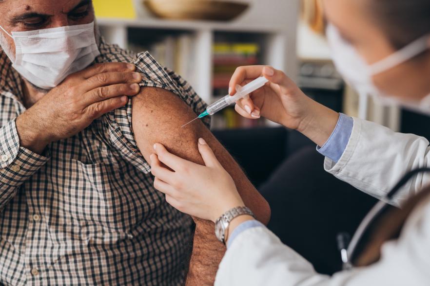 Image of a man getting a vaccine for a healthcare professional