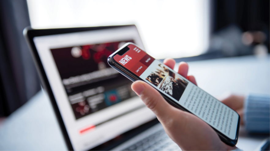 News cover image featuring the news on a laptop and mobile phone